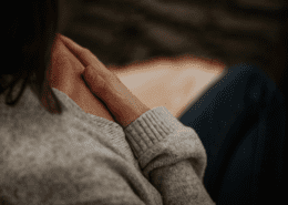 A woman sitting in meditation with her hand on her heart