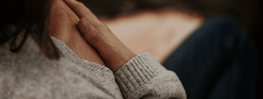 A woman sitting in meditation with her hand on her heart