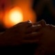 A shamanic healer's hands are gently placed over rthe eyes of a woman during a healing session