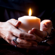 female hands holding a burning candle