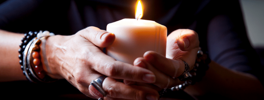 female hands holding a burning candle